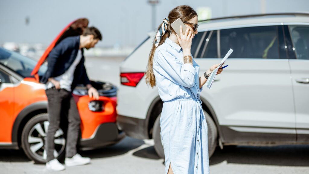 Frau ruft mit Telefon nach dem Autounfall an