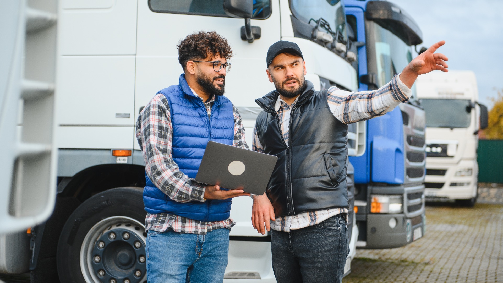 Logistikleiter bespricht Flottendaten mit einem Lkw-Fahrer