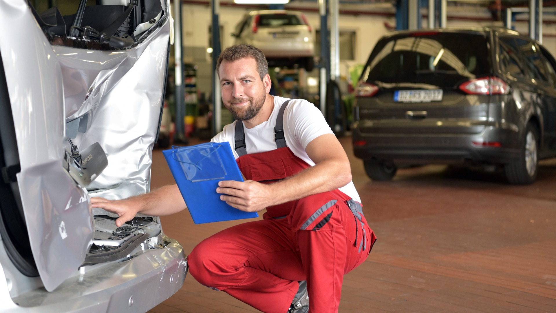Gutachten bei kaputten Unfallwagen in einer Autowerkstatt nach Verkehrsunfall
