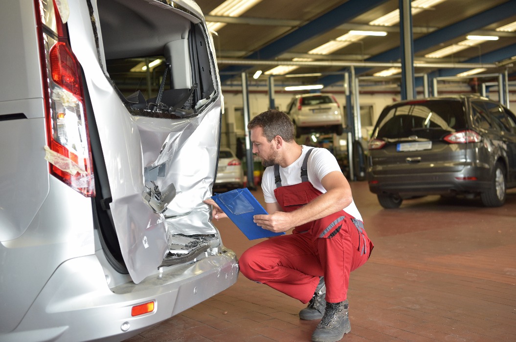 Begutachtung eines Unfallschadens in der Autowerkstatt durch Mechaniker/ Sachverständiger für Versicherung nach Autounfall // Expert opinion on accident damage in the car repair shop